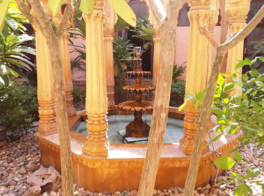 a water fountain surrounded by trees and rocks